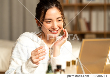 年輕女子晚上照顧她的皮膚 年輕女子晚上照顧她的皮膚 80500711