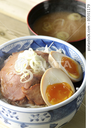 一套熱氣騰騰的烤豬肉碗和味噌湯,上面放著捲心菜絲、味噌球和大蔥 一套熱氣騰騰的烤豬肉碗和味噌湯,上面放著捲心菜絲、味噌球和大蔥 80501179