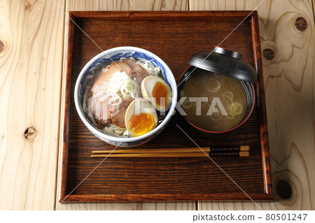 一組熱氣騰騰的烤豬肉碗和味噌湯的鳥瞰圖,上面放著捲心菜絲、味噌球和大蔥。 一組熱氣騰騰的烤豬肉碗和味噌湯的鳥瞰圖,上面放著捲心菜絲、味噌球和大蔥。 80501247