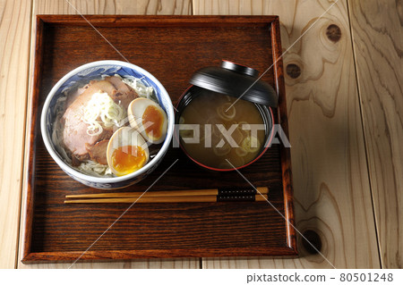 一組熱氣騰騰的烤豬肉碗和味噌湯的鳥瞰圖,上面放著捲心菜絲、味噌球和大蔥。 一組熱氣騰騰的烤豬肉碗和味噌湯的鳥瞰圖,上面放著捲心菜絲、味噌球和大蔥。 80501248