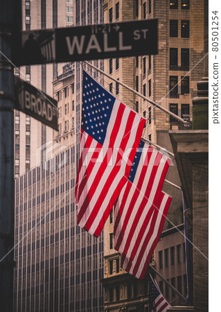 Wall street sign in New York with American flags and New York Stock Exchange in background 80501254