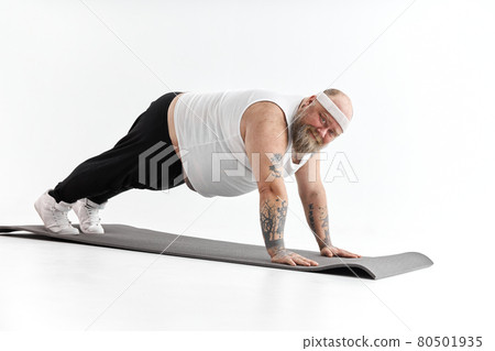 Sporty fat man with beard and tattoos is doing yoga 80501935