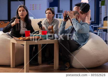 Team of multi ethnic friends losing tv game on console 80502628