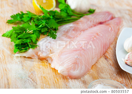Fillet of fresh raw perch fish with greens on a wooden surface 80503557