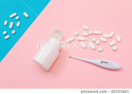 White Pills or Tablets Scattered from the Pill Container with Electronic Thermometer White Pills or Tablets Scattered from the Pill Container with Electronic Thermometer 80503663
