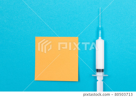 Vaccination or Revaccination Concept - A Medical Syringe on Blue Table 80503713