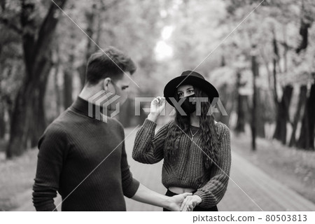 Young couple wearing masks together in forest Young couple wearing masks together in forest 80503813