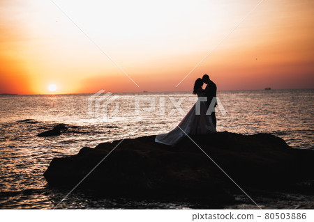 Happy and romantic scene of just married young wedding couple posing on beautiful beach Happy and romantic scene of just married young wedding couple posing on beautiful beach 80503886