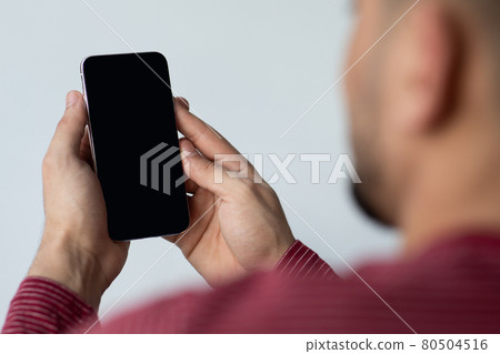 Unrecognizable guy using smartphone with blank screen Unrecognizable guy using smartphone with blank screen 80504516