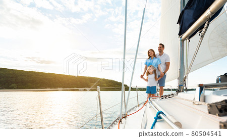 Joyful Family Standing On Sailboat Deck Enjoying Yacht Ride 80504541