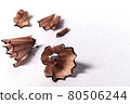 Macro detail closeup of wooden curly pencil shavings on white paper background - Concept of studying, school homework, planning, drawing or writing 80506244