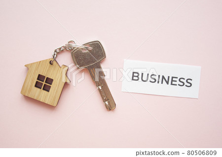 Wooden house toy and silver key on bright pink 80506809