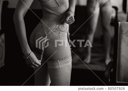 a close - up of the beautiful figure of a girl who is dressed in underwear is visible from behind.Black and white photo a close - up of the beautiful figure of a girl who is dressed in underwear is visible from behind.Black and white photo 80507926