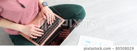 Woman sitting on floor with laptop and documents top view 80508029