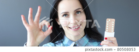 Young woman holding birth control pills and showing okay gesture Young woman holding birth control pills and showing okay gesture 80508053