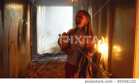 Terrified girl standing in burning building Terrified girl standing in burning building 80508120