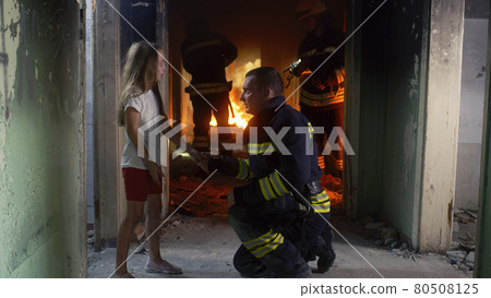 Girl speaking with fireman in burning building Girl speaking with fireman in burning building 80508125
