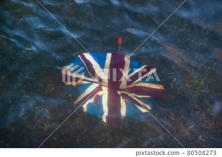 Broken umbrella with Union Jack on it, discarded in shallow river. Broken umbrella with Union Jack on it, discarded in shallow river. 80508273