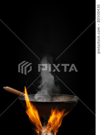 Empty wok pan with smoke above fire with sparks against black background. Cooking concept. Mockup, template for your collage, text, images. Close up 80508436