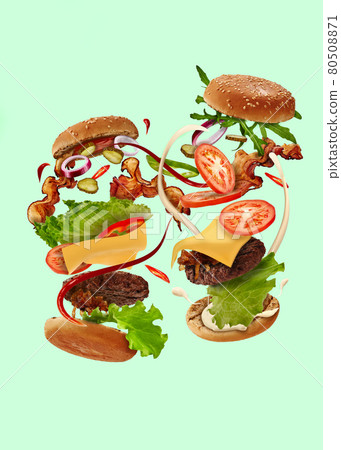 Two tasty burgers with flying ingredients on pale green background. Ham, beef cutlet, cheese, ketchup, mayonnaise, vegetables and greens. Close up Two tasty burgers with flying ingredients on pale green background. Ham, beef cutlet, cheese, ketchup, mayonnaise, vegetables and greens. Close up 80508871