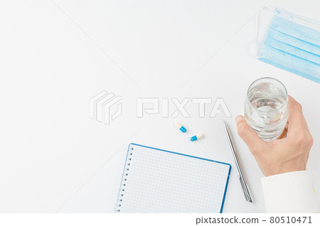 Hand with glass of water and pill white background 80510471