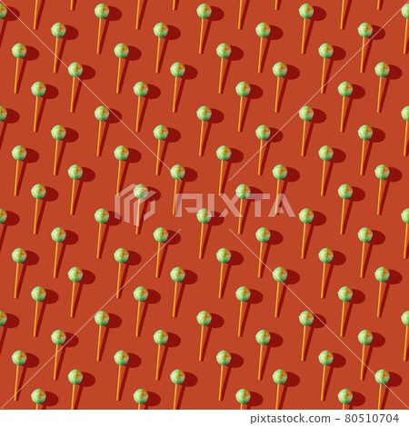 Photo in the form of a seamless pattern. Candy on a stick with shadows on a colored orange 80510704