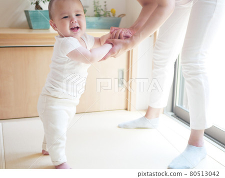 Half-baby holding her mother's hand and standing Half-baby holding her mother's hand and standing 80513042