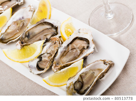 Tasty oysters with lemon on plate top view Tasty oysters with lemon on plate top view 80513778