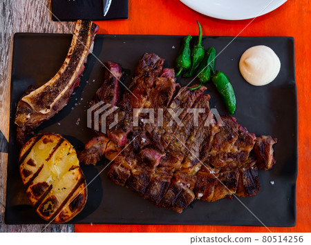 Sliced fried beef chop with sauce, grilled potato and peppers Sliced fried beef chop with sauce, grilled potato and peppers 80514256