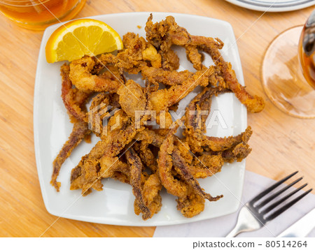 Popular Spanish tapa rejos - fried spicy tentacles of squid served with lemon slice 80514264