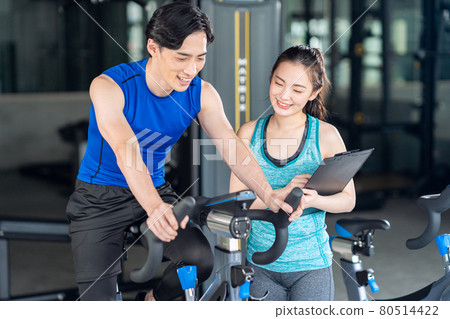 Fitness instructor sports gym exercise bike training exercise Fitness instructor sports gym exercise bike training exercise 80514422