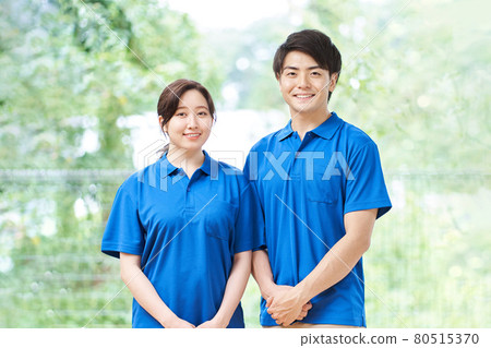 Male and female caregivers standing on a green background 80515370