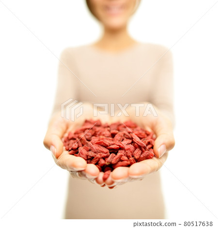Goji berries - dried Goji berry heap wolfberries. Superfoods - woman showing dried goji berries. Heap of organic healthy wolfberry superfood. 80517638