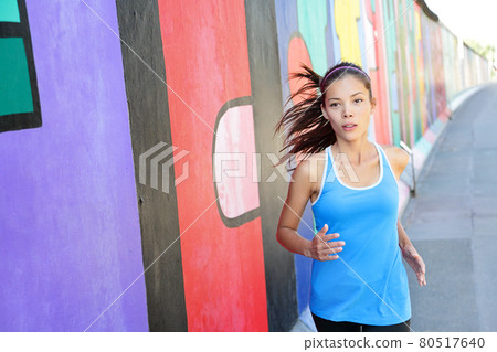 Running woman jogging by Berlin Wall, Germany 80517640