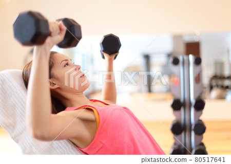 Gym woman strength training lifting weights 80517641