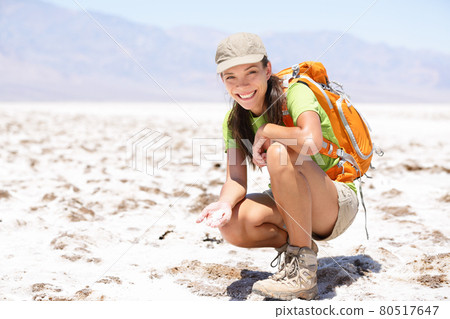 Death Valley. Hiker woman in Death Valley, California, USA showing dried out salt in Badwater Basin. 80517647