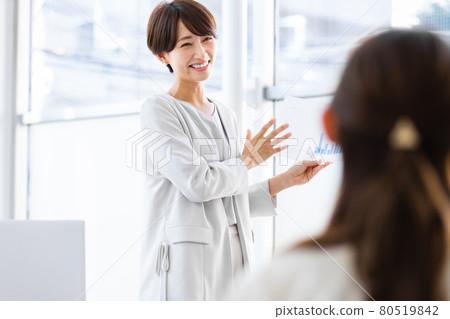 一位拿著紙質材料在公共場合講話的女商人 80519842
