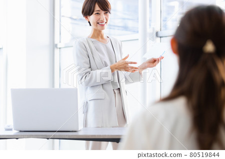 A business woman holding paper materials and talking in public 80519844