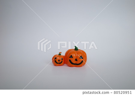 Two smiling orange pumpkin candles side by side 80520951