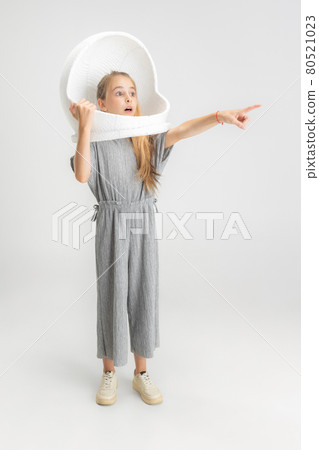 Portrait of little school caucasian girl in large helmet posing isolated over white studio background. Portrait of little school caucasian girl in large helmet posing isolated over white studio background. 80521023