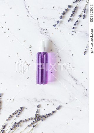 Bottle of skincare tonic water with dried lavender herbs top view on white marble background top view. 80522068