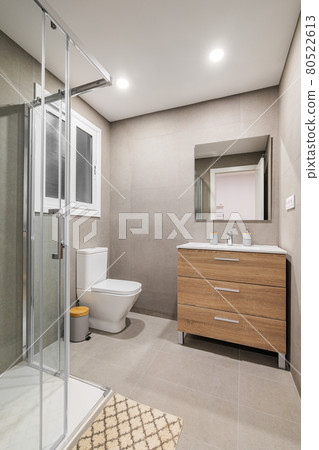 Modern refurbished bathroom with shower zone, toilet, wooden base with white sink and mirror. Modern refurbished bathroom with shower zone, toilet, wooden base with white sink and mirror. 80522613