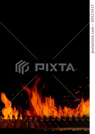Empty hot barbecue BBQ grill grid with burning fire, sparks and smoldering charcoal on black background. Cooking concept. Close up, copy space 80523437