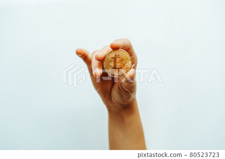 Bitcoin in hand on a light background. 80523723