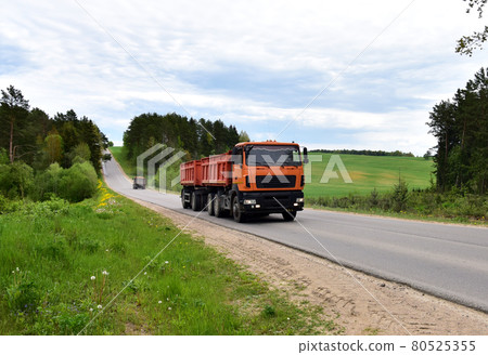 Tipper dump truck transported sand from the quarry on driving along highway.  80525355
