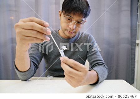 Man uses cotton swab to test for Covid-19 Insert a reagent bottle to look for what is believed to be a virus. 80525467