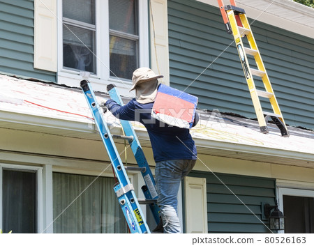 Contractor climbing ladder carring package of roof shingles Contractor climbing ladder carring package of roof shingles 80526163