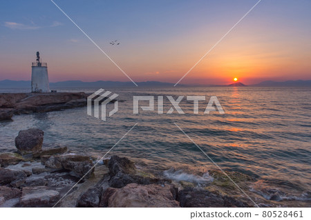 Old small lighthouse of the Aegina island, Saronic gulf, Greece, at sunset. 80528461