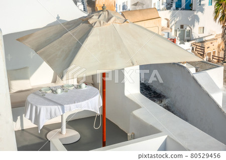 Served Table Under an Umbrella on the Terrace of Santorini Served Table Under an Umbrella on the Terrace of Santorini 80529456