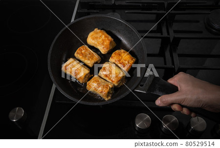 Stuffed cabbage on skillet pan and in human hand Stuffed cabbage on skillet pan and in human hand 80529514